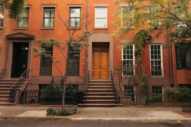 Facade of building with steps and doors on urban street in brooklyn heights in New York City clipart