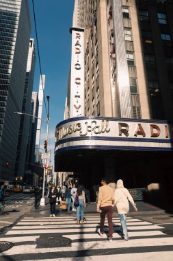 NEW YORK, USA - OCTOBER 11, 2022: People walking near music radio hall on urban street 