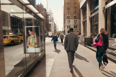 NEW YORK, USA - OCTOBER 11, 2022: People walking on sidewalk on city street 