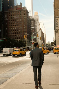 NEW YORK, USA - OCTOBER 11, 2022: Man walking on sidewalk on urban street in Manhattan  clipart