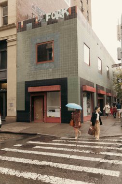 NEW YORK, ABD - 11 Ekim 2022: Yağmur sırasında şehir caddesinde yürüyen insanlar 