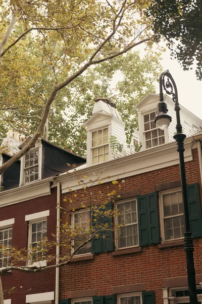 old house with attic windows near lantern and trees in Brooklyn Heights district of New York City