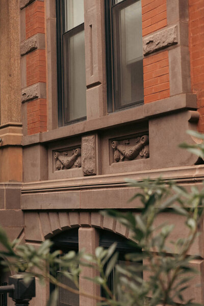 brick building with grey stone decor on urban street of Brooklyn Heights district in New York City