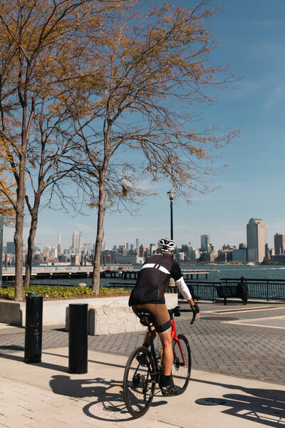 NEW YORK, USA - OCTOBER 11, 2022: Man biking on Hudson river waterfront walkway at daytime 