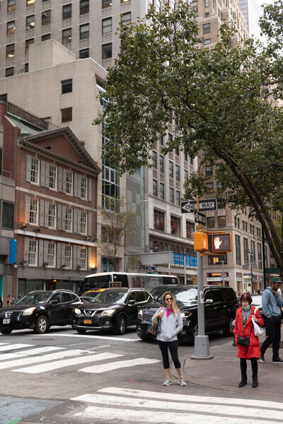 NEW YORK, USA - OCTOBER 11, 2022: People standing near traffic light on urban street in Manhattan 