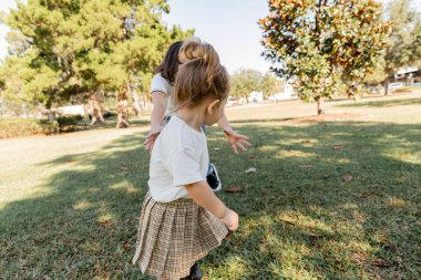 Anne ve etekli tatlı kız Miami parkında birlikte oynuyorlar. 