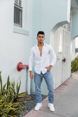 Miami 'de sokakta poz veren şık gömlekli ve kot pantolonlu Kübalı bir adam.