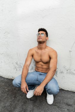 Miami 'de şehir sokağında şık gözlüklü ve kot pantolonlu genç ve seksi Kübalı adam.