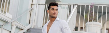 Kıvırcık saçlı ve beyaz gömlekli Kübalı adam Miami 'deki şehir sokağına bakıyor. 
