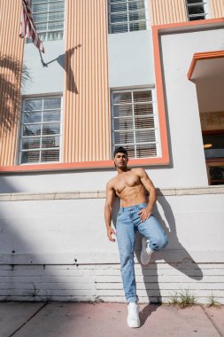 Beyzbol şapkalı ve kotlu seksi Kübalı adam Miami caddesinde duruyor.