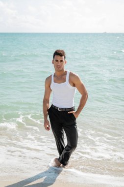 Miami South Beach, Florida 'da okyanus suyunda duran yakışıklı kaslı genç Kübalı adam.