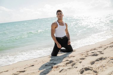 Okyanus kıyısında ve Miami South Beach, Florida 'da sahilde poz veren şık giyinmiş genç Kübalı adam.