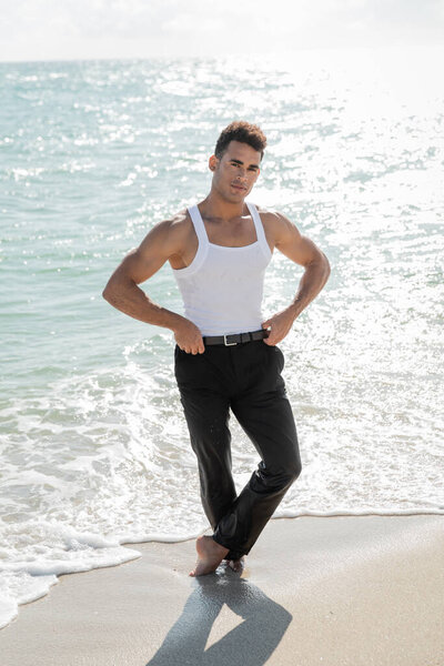handsome and muscular Cuban man standing in ocean water in Miami South Beach, Florida