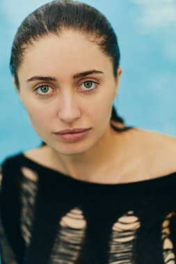 Yakın çekim, doğal güzellik, makyajsız görünüş, siyah örgülü seksi esmer kadın Miami 'de tatil sırasında yüzme havuzunda poz veriyor, kameraya bakıyor, portre çiziyor. 