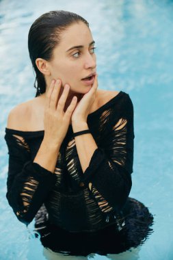 Miami 'de lüks bir tatil yeri, bronz tenli bir kadın yüzme havuzunda yüzdükten sonra ıslak yüzüne dokunuyor, poz veriyor ve yaz tatilinin tadını çıkarıyor, makyajsız. 