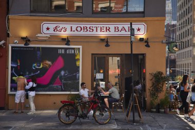 NEW YORK, USA - NOVEMBER 26, 2022: eds lobster bar, pedestrians and bicycle on street in soho clipart