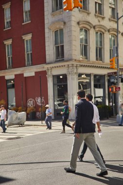 NEW YORK, USA - NOVEMBER 26, 2022: pedestrians crossing road in new york city on autumn day clipart