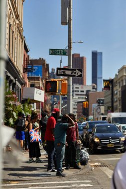 NEW YORK, USA - NOVEMBER 26, 2022: busy avenue with crowd of people and heavy traffic in downtown clipart