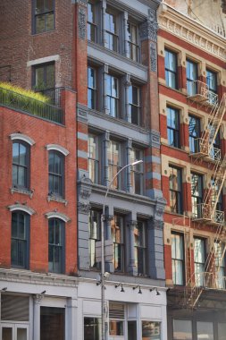 New York şehir merkezinde yangın merdivenleri olan klasik binalar, sonbaharda sokak manzarası.