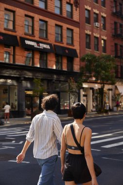 NEW YORK, ABD - 26 Kasım 2022: şehir merkezinde cadde boyunca yürüyen şık bir çiftin arka görüntüsü