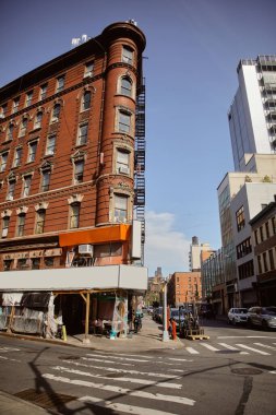 red brick building with store under reconstruction on crossroad in chinatown of new york city clipart