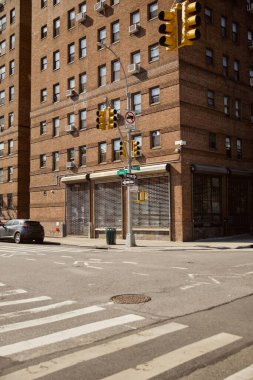 New York 'ta trafik ışıklarıyla kavşakta kapalı dükkan vitrinli kırmızı tuğla bina