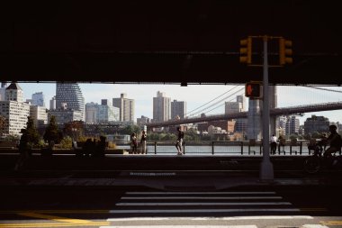 NEW YORK, ABD - 26 Kasım 2022: Manhattan Köprüsü manzaralı Doğu Nehri seti üzerindeki insanlar