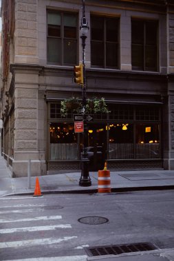 New York 'ta restoranı olan binanın yakınında çiçek saksıları ve trafik ışıkları olan sokak direği.