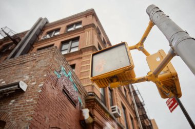 New York 'taki tuğla binaların yanında trafik ışıkları olan sokak direğinin alçak açılı görüntüsü