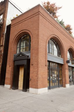 New York 'un şehir merkezinde kapısı ve kemerli penceresi olan tuğla bina, şehir mimarisi