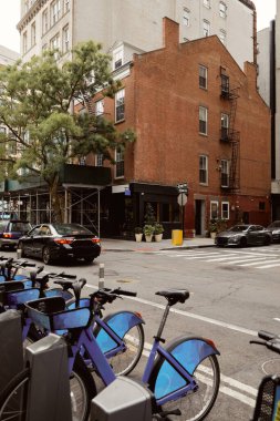 New York 'ta şehir merkezindeki bulvarda, sonbahar sahnesinde, motosiklet parkı ve arabalar kavşakta ilerliyor.