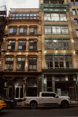 New York caddesi, modern arabalarla taştan binalar boyunca ilerleyen büyük pencereli