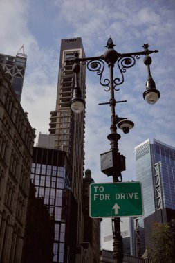 New York 'ta modern bina ve gökdelenlere karşı fenerli sokak direği ve trafik levhası