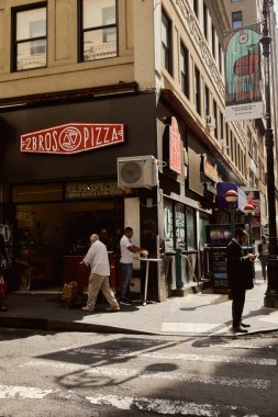 NEW YORK, ABD - 26 Kasım 2022 Pizzacı ve yayalar şehir merkezinde kaldırımda