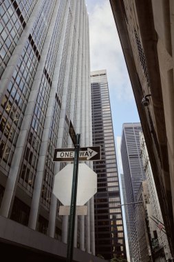 New York 'taki modern binaların ve gökdelenlerin yakınındaki tek yönlü yol tabelasının alçak açılı görüntüsü
