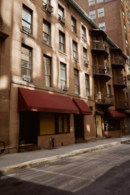 low story stone building with balconies on narrow and cozy street, new york city architecture clipart