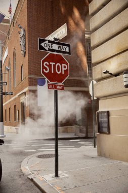 New York şehir merkezinde, metropol atmosferinde yol işaretleri ve klasik binaların yanında buhar.