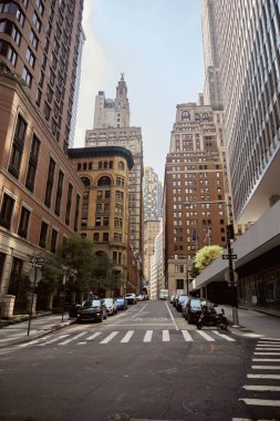 NEW YORK, ABD - 26 Kasım 2022: New York 'ta sonbahar yeşillikleri olan binalar ve ağaçların yakınındaki bulvara park edilmiş arabalar, sonbahar manzarası