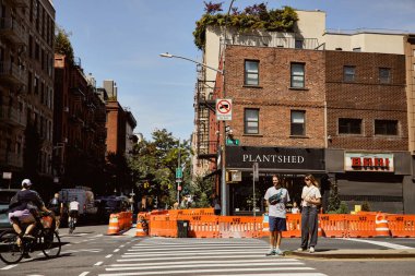 NEW YORK, USA - NOVEMBER 26, 2022: plantshed flower shop, pedestrians and cyclists on street clipart