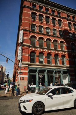 NEW YORK, ABD - 26 Kasım 2022: Kırmızı vintage binalar ve yürüyen insanlarla dolu cadde