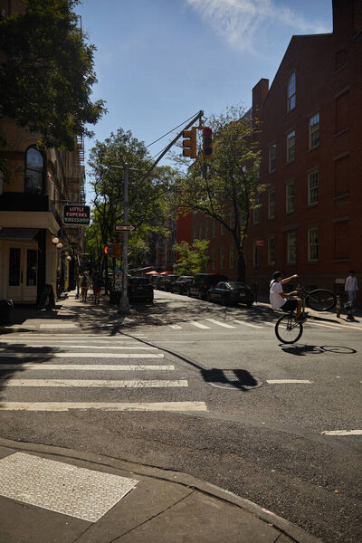 NEW YORK, USA - NOVEMBER 26, 2022: cyclist doing trick on bicycle while crossing city road
