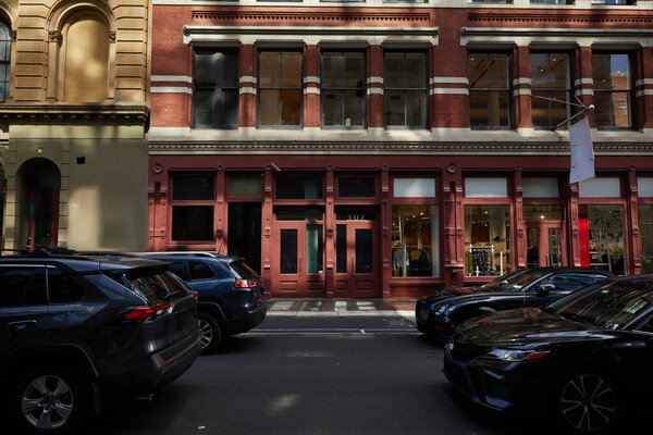 urban district with vintage buildings and cars moving on roadway on fall day in new york city