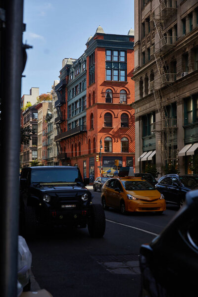 cars moving on street with vintage buildings in downtown district of new york city, rush hour