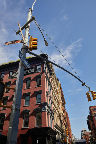 low angle view of street pole with road signs and traffic lights near buildings in new york city