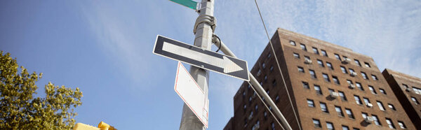 низкий угол обзора уличного столба с дорожными знаками возле здания из красного кирпича в Нью-Йорке, баннер