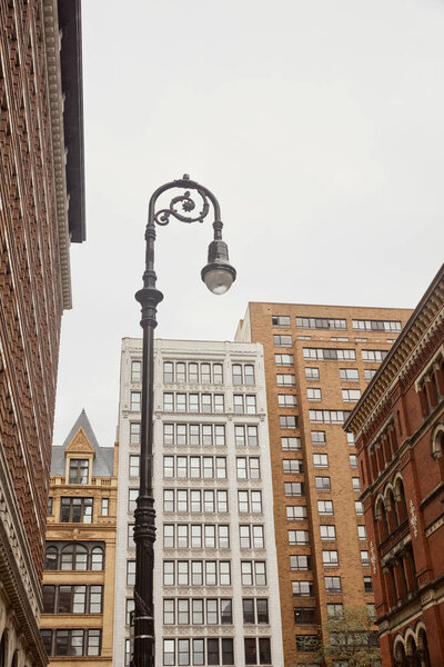 low angle view of decorated lantern near contemporary buildings in new york city, urban architecture