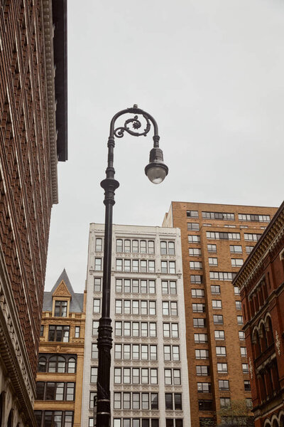 low angle view of decorated lantern near modern buildings in new york city, urban architecture