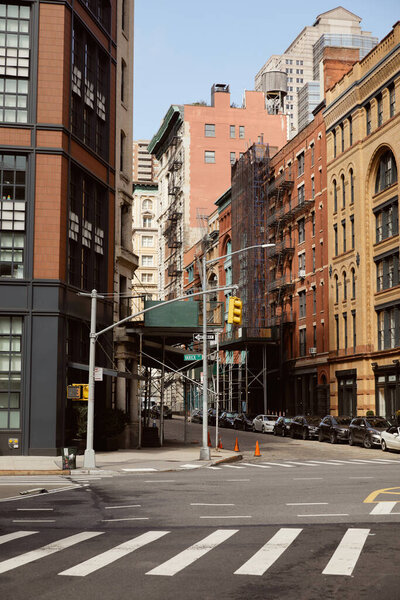 New york street with modern and vintage buildings near traffic intersection with pedestrian crossing