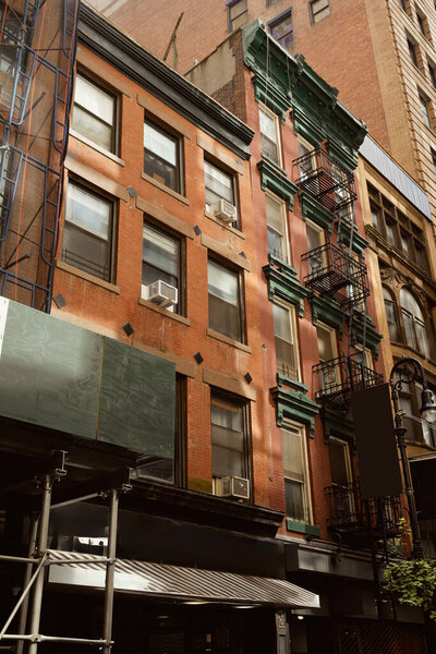 Red brick building with fire escape stairs in downtown of new york city, urban architecture