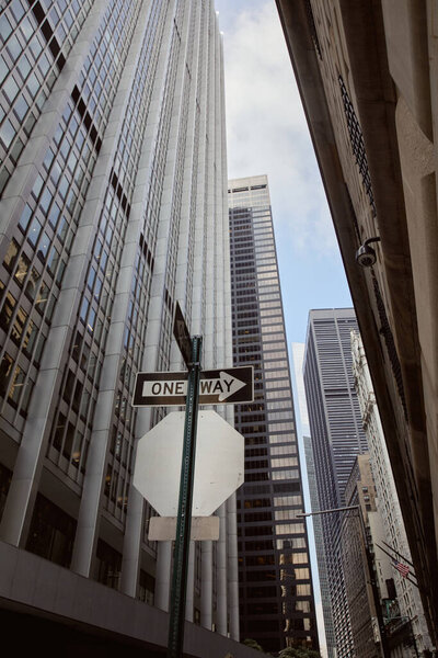 Low angle view of one way road sign near modern buildings and skyscrapers in new york city